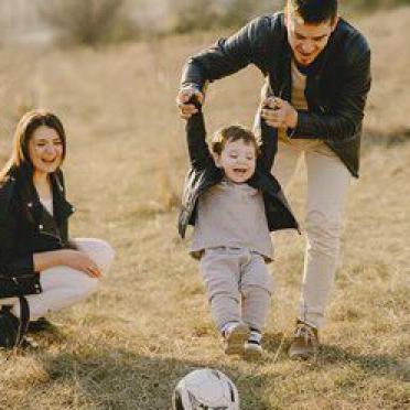 Familie am Ballspielen mit Kind