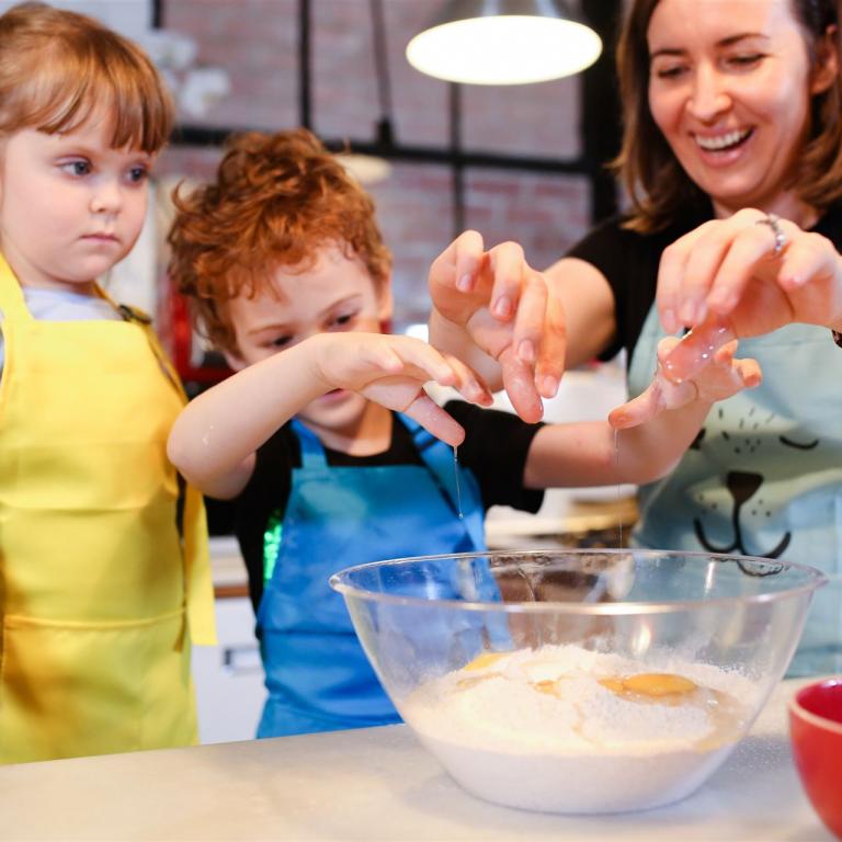 Mutter mit beiden Kinder in der Küche am Kochen