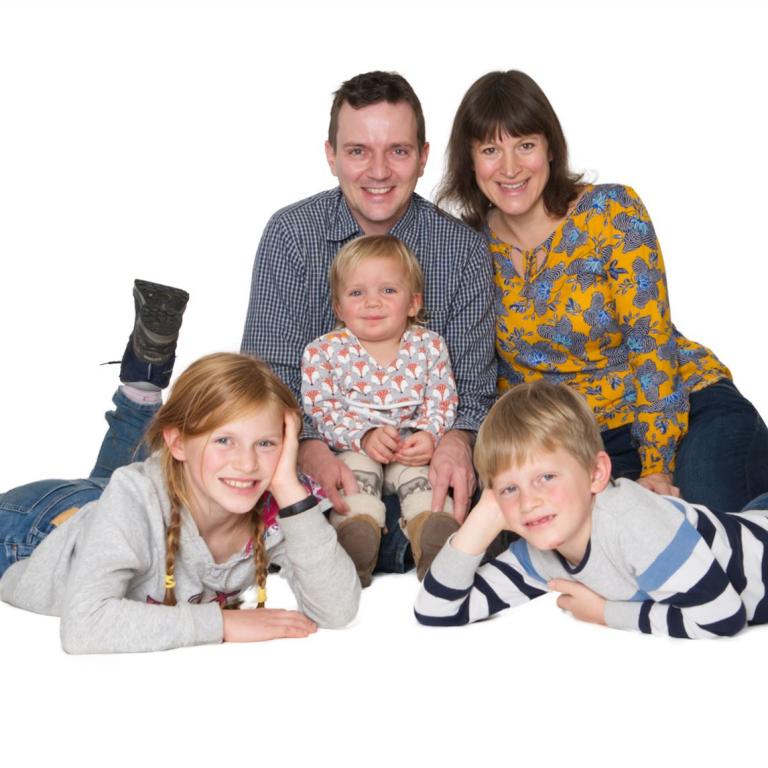 Familienfoto im Studio vor weissem Hintergrund am Boden sitzend